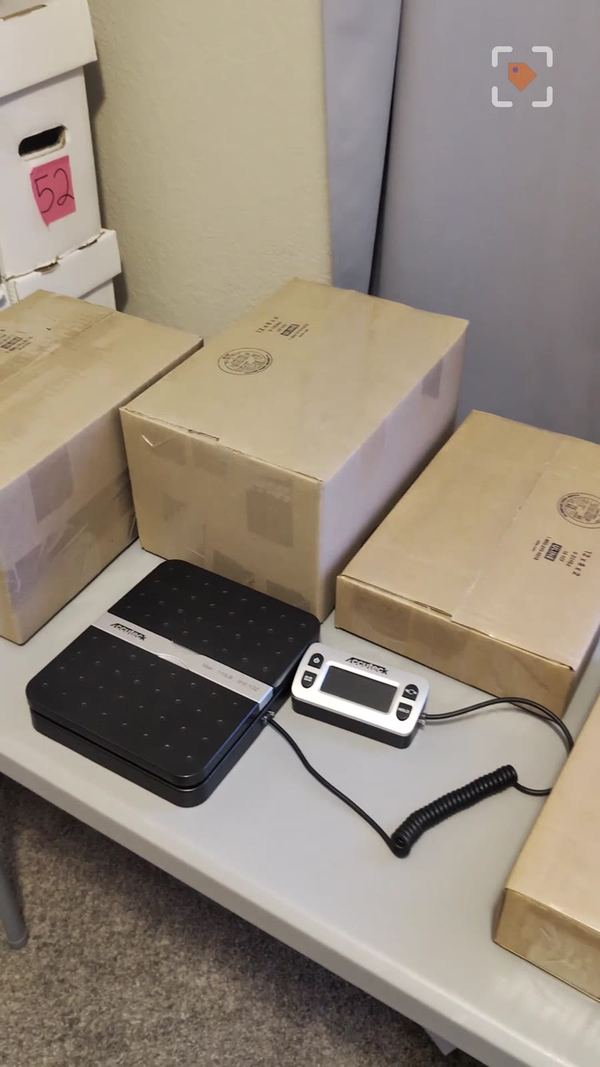 Packed comic boxes next to a digital shipping scale